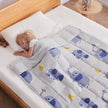 Child peacefully sleeping under Anfie sensory weighted blanket featuring playful elephants on a grey background.
